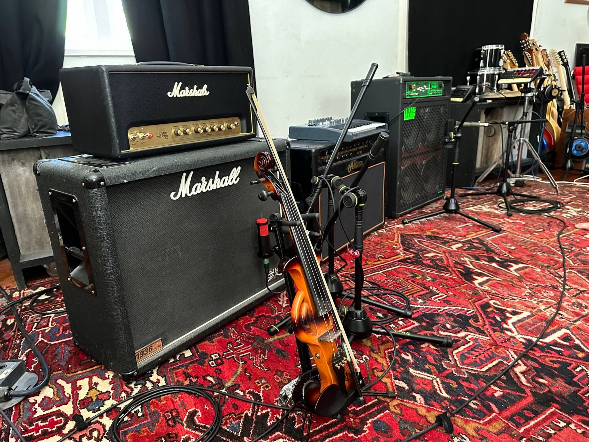 Guitar and bass amps set up in the studio for recording.
